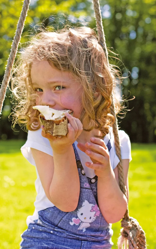 Gastronomie, fillette mangeant une tartine beurée