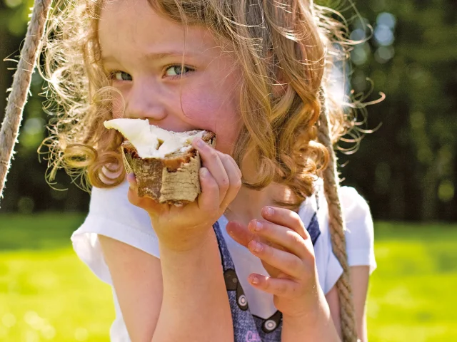 Gastronomie, fillette mangeant une tartine beurée