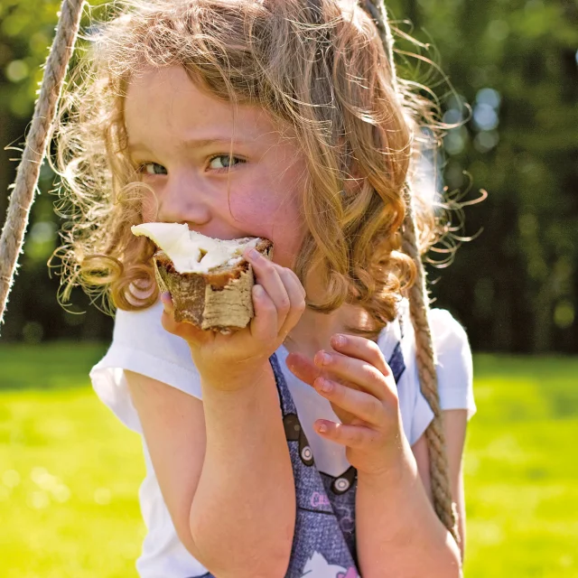 Gastronomy, little girl eating buttered toast