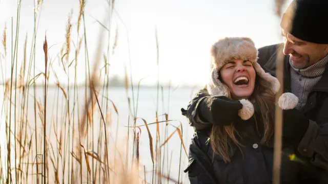 Couple se promenant au bord d'un étang, l'hiver