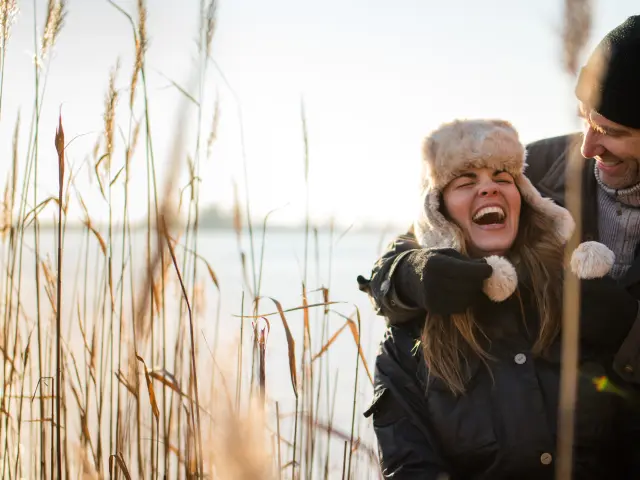 Couple se promenant au bord d'un étang, l'hiver