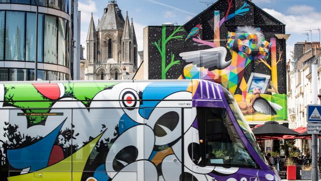 Tramway habillé du thème Les Ecouteurs de Jean Moderne dans le cadre d'Échappées d'Art 2019, devant la fresque Apocalypsis, placette Saint-Aubin et place du Ralliement
