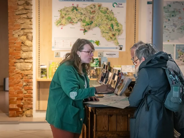 Conseillère en séjour renseignant des visiteurs à l'accueil d'Alençon Tourisme