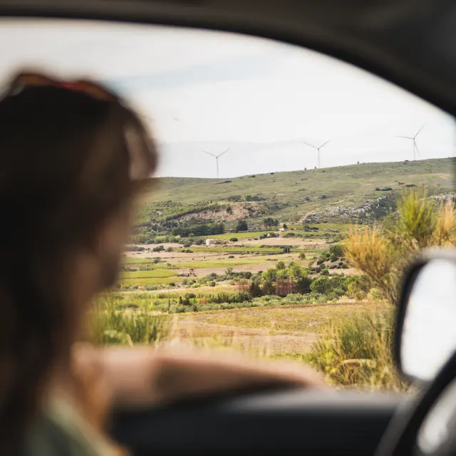 Femme en voiture devant les vignes, vignoble, vignes, campagne, route, voiture, conducteur, femme, paysage, nature, verdoyant, colline, ciel, ensoleillé, lumière naturelle, extérieur, horizontal, flou