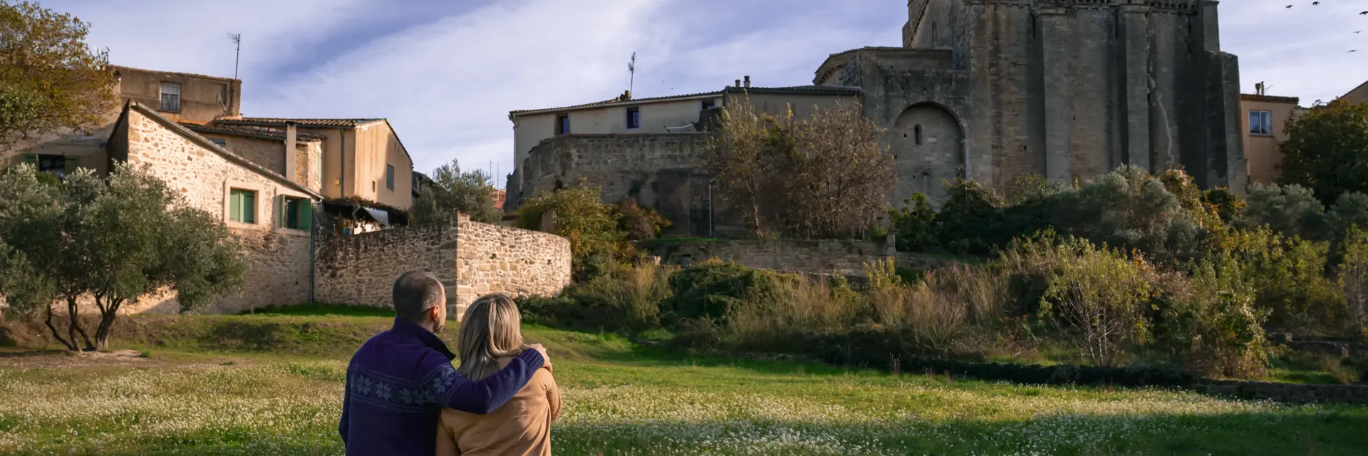Couple devant la chapelle Saint-Pierre de Montbazin, jardin méditerranéen.