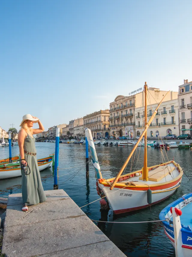 Junge Frau am Kai von Sète mit Blick auf die Kanäle und traditionelle Boote.Frau, allein, Boot, Landschaft, Kleid, Himmel, Wasser