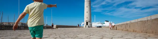 Un enfant court vers le phare Saint-Louis, môle.