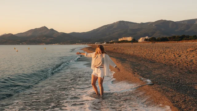 Jeune fille pieds dans l'eau en automne avec vue sur la montagne au loin