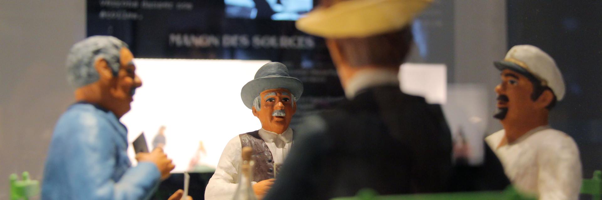 Santons représentant une scène provençale en discussion dans une exposition muséale au Petit Monde à Aubagne