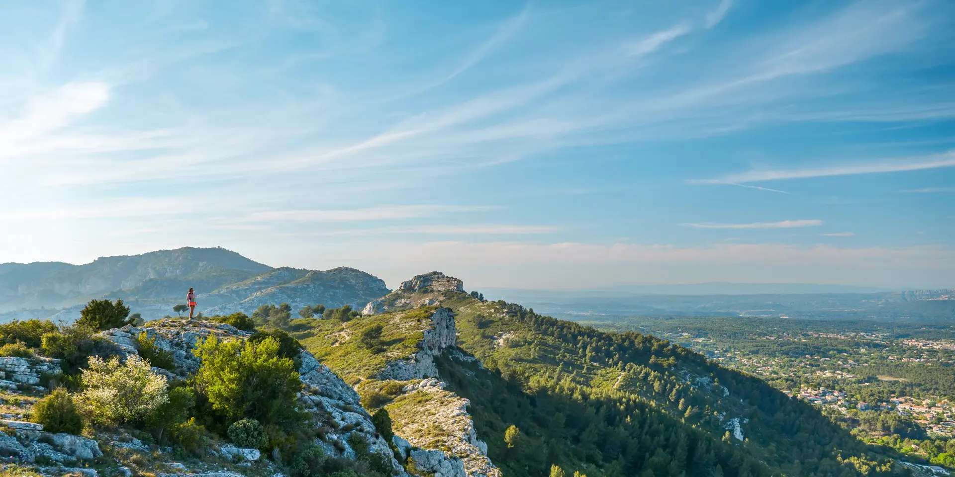 Massif calcaire de l'Etoile avec végétation méditerranéenne au premier plan, dominant des collines boisées et une plaine visible à l’horizon sous un ciel dégagé.