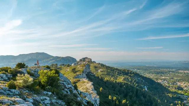 Massif calcaire de l'Etoile avec végétation méditerranéenne au premier plan, dominant des collines boisées et une plaine visible à l’horizon sous un ciel dégagé.