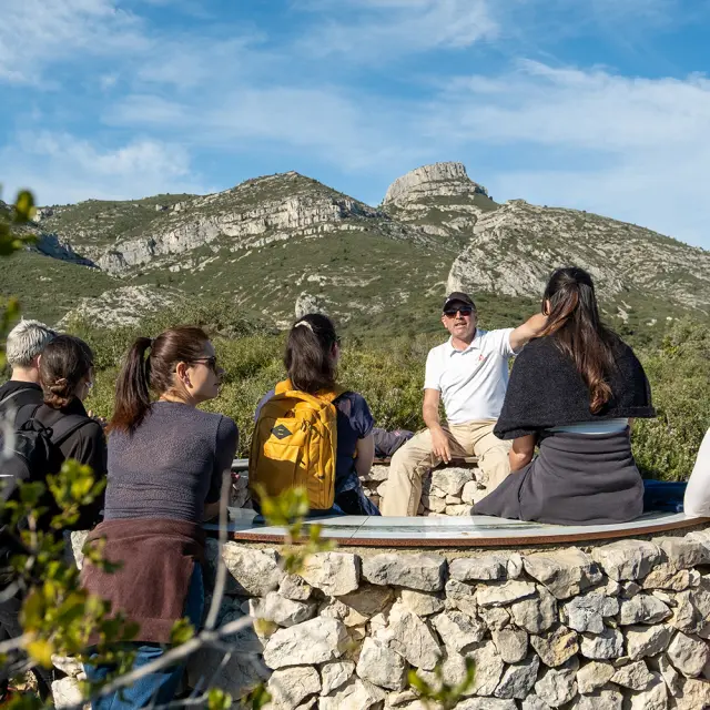 Groupe de visiteurs à la table d'orientation de la font de mai, avec le garlaban en fond