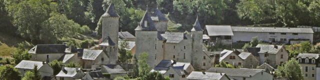 Saint Saturnin and its 14th-century castle at the foot of the Causse de Sauveterre cliffs in the Urugne valley.