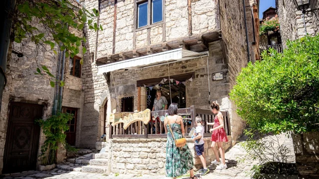 Une famille discute avec une commerçante de Sainte-Enimie