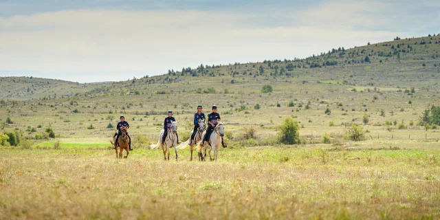 A group of horsemen ride on the Causse Méjean