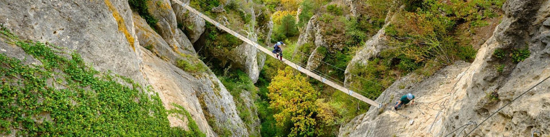 A group accompanied by a guide crosses a footbridge on the Liaucous Via Ferrata.