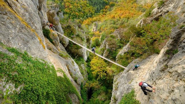 A group accompanied by a guide crosses a footbridge on the Liaucous Via Ferrata.