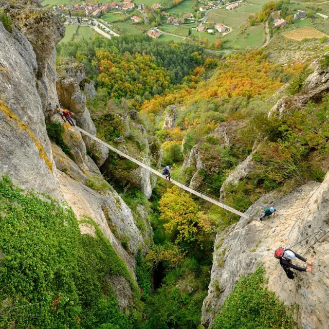 A group accompanied by a guide crosses a footbridge on the Liaucous Via Ferrata.