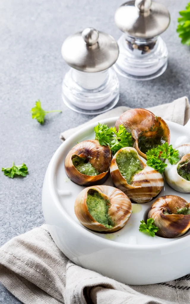 Bourgogne Escargot Snails with garlic herbs butter in white pan on light gray background. Gesundes Konzept mit Kopierraum.