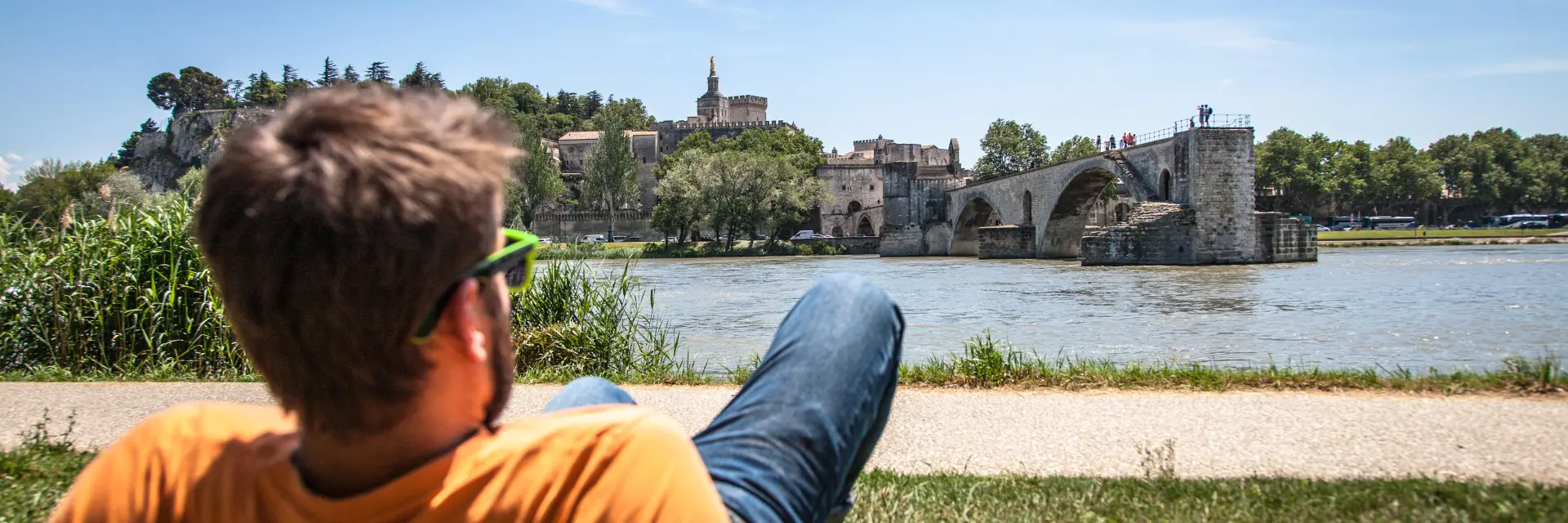 Garçon assis sur la Barthelasse face au Pont d'Avignon. Crédit : Frédéric Dahm / Empreintes d'Ailleurs
