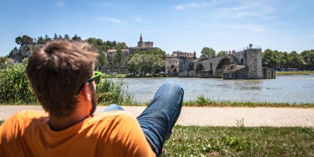 Junge sitzt auf der Barthelasse gegenüber der Brücke von Avignon. Credit: Frédéric Dahm / Empreintes d'Ailleurs