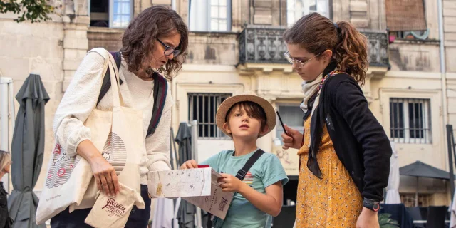 Famille jouant à Intrigue dans la Ville | De Beaux Lents Demains