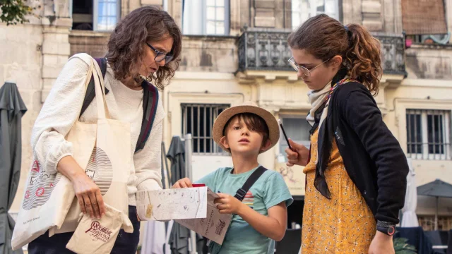 Famille jouant à Intrigue dans la Ville | De Beaux Lents Demains