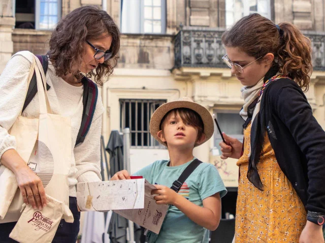 Famille jouant à Intrigue dans la Ville | De Beaux Lents Demains