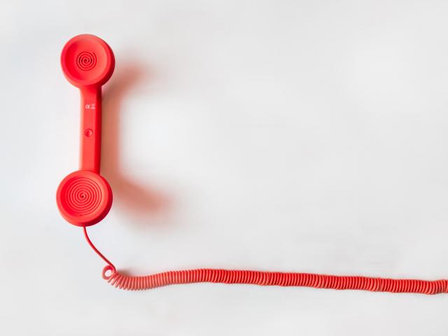 Téléphone Aide Canva Red Corded Telephone On White Suraface