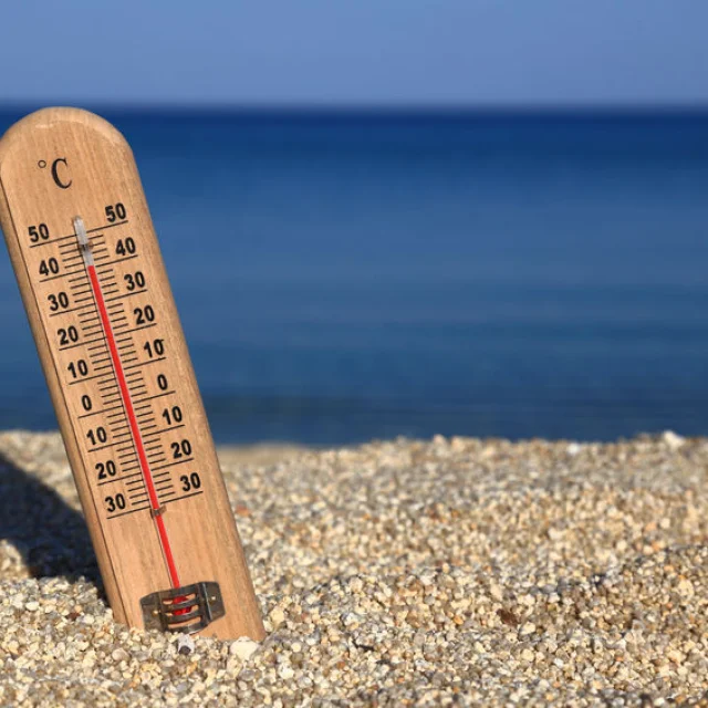 Thermometer on a beach shows high temperatures
