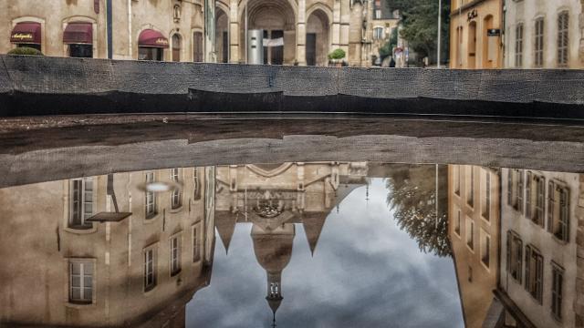 Collegiate church on a rainy day mirror water fountain Beaune