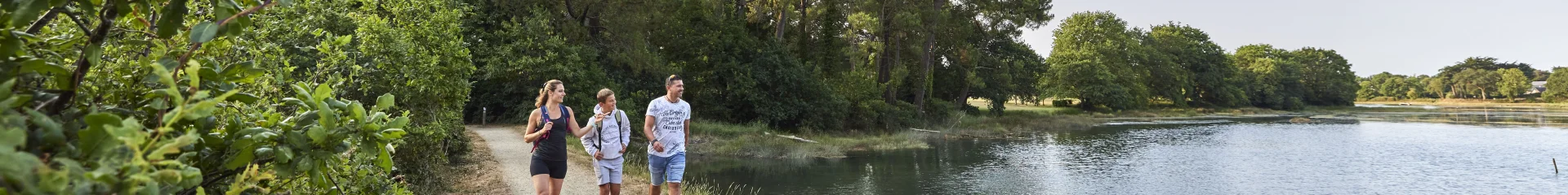 Famille en promenade sur les chemins des marais de l'Anse du Petit Moulin, près de la Mer Blanche à Bénodet