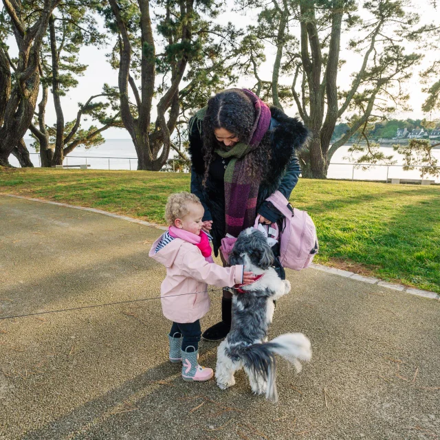Petite fille et sa maman qui caressent un chien rencontré près de la Pointe du Coq