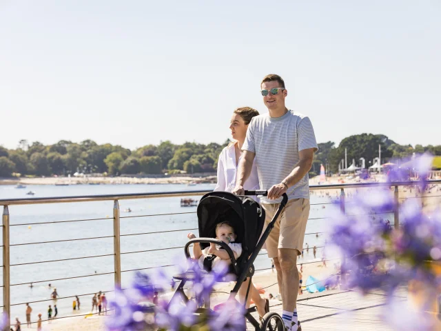 Paar mit Kinderwagen bei einem Spaziergang entlang des Plage du Trez