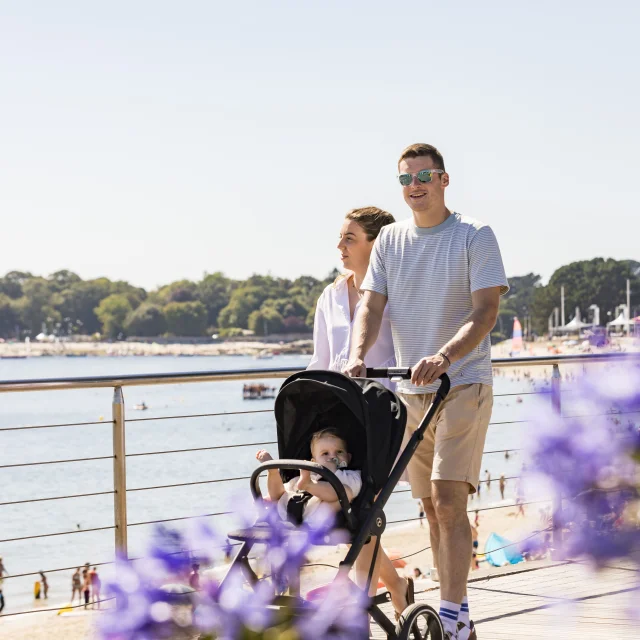 Paar mit Kinderwagen bei einem Spaziergang entlang des Plage du Trez