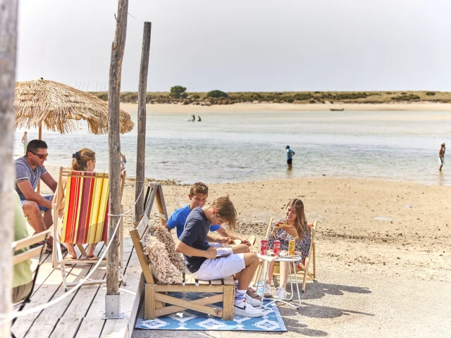 Gruppe von Teenagern bei einem Snack in der Paillotte am Plage du Letty