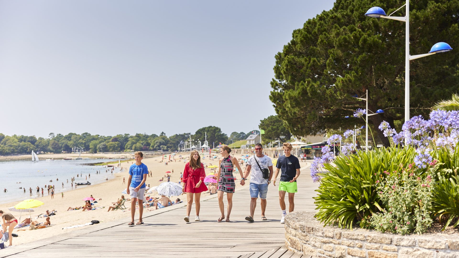 Familie beim Spaziergang auf der Esplanade am Plage du Trez