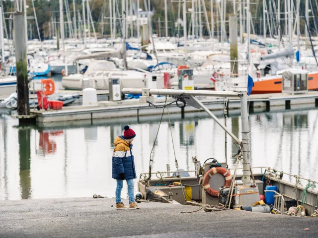 Petit garçon observant un bateau sur la port de plaisance de Bénodet