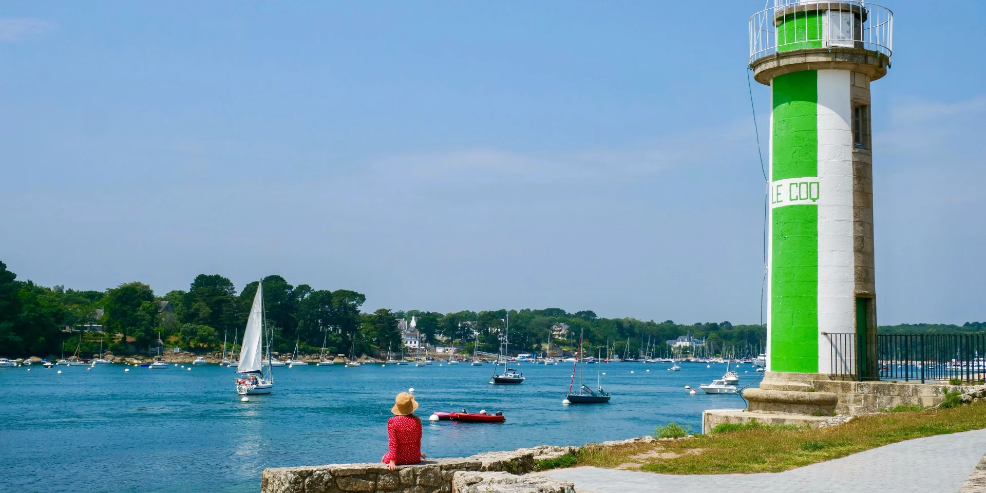 Jeune femme assise près du Phare du Coq à Bénodet