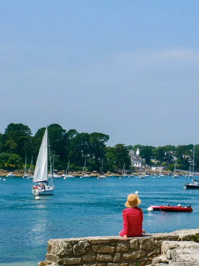 Jeune femme assise près du Phare du Coq à Bénodet