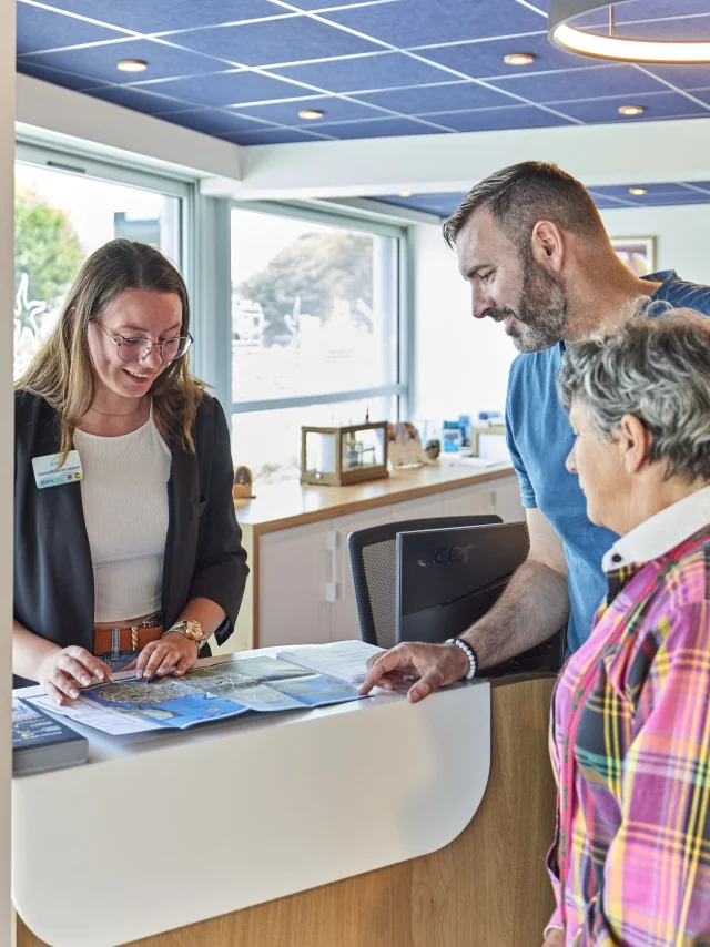 Conseillère en séjour renseignant des visiteurs à l'Office de Tourisme de Bénodet