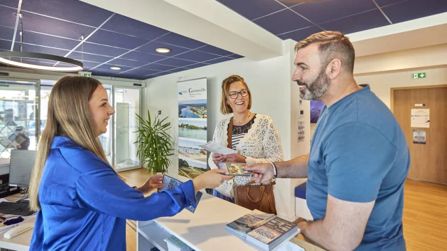 Conseillère en séjour renseignant des visiteurs à l'Office de Tourisme de Bénodet