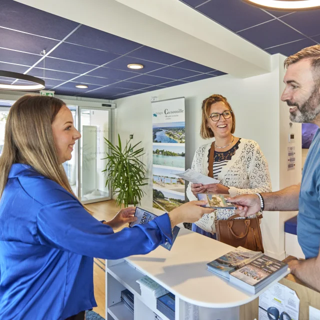 Conseillère en séjour renseignant des visiteurs à l'Office de Tourisme de Bénodet