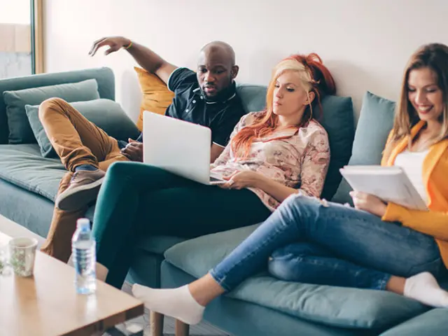 Roommates sitting on a sofa in a modern shared apartment in Brussels