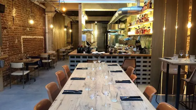 Salle du restaurant Holy Smoke à Bruxelles avec grande table en bois