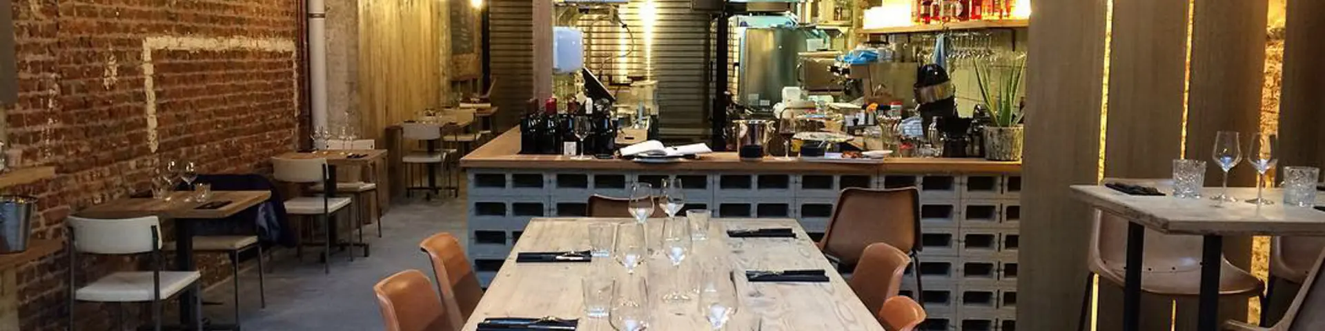 Salle du restaurant Holy Smoke à Bruxelles avec grande table en bois