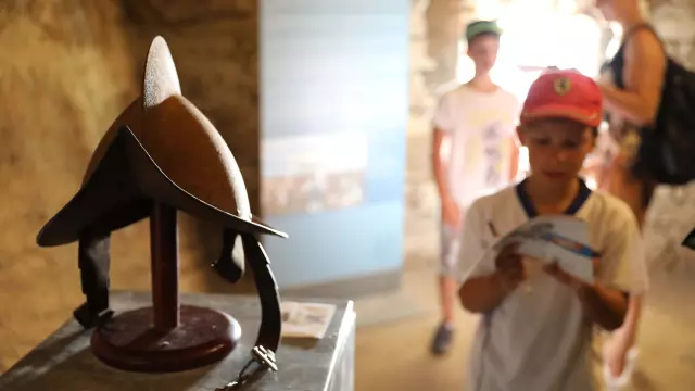 Enfant visitant le Bastion de l'Etendard à l'aide du livret jeu à Bonifacio