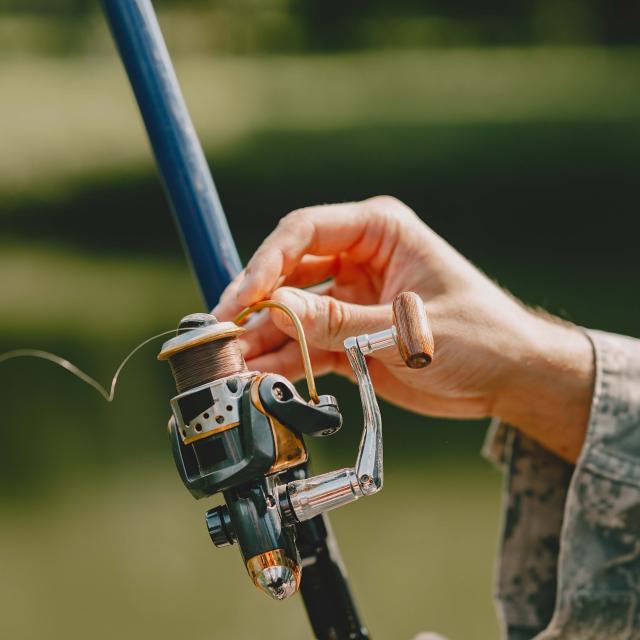 A man fishing on a lake. Guy in a uniform.