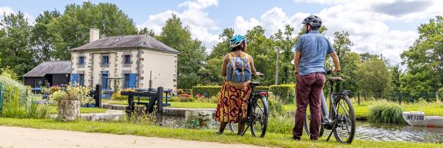 A vélo devant une maison éclusière du canal d'Ille-et-Rance