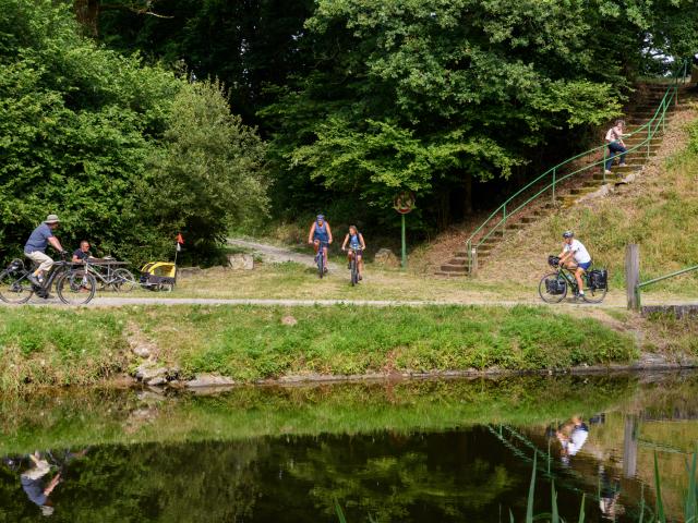 Cyclotouristes se croisant sur le chemin de halage le long du Canal de Nantes à Brest et à la rampe d'accès aux Voies Vertes et à la Vélodyssée, à Pont ar Brost à Carhaix